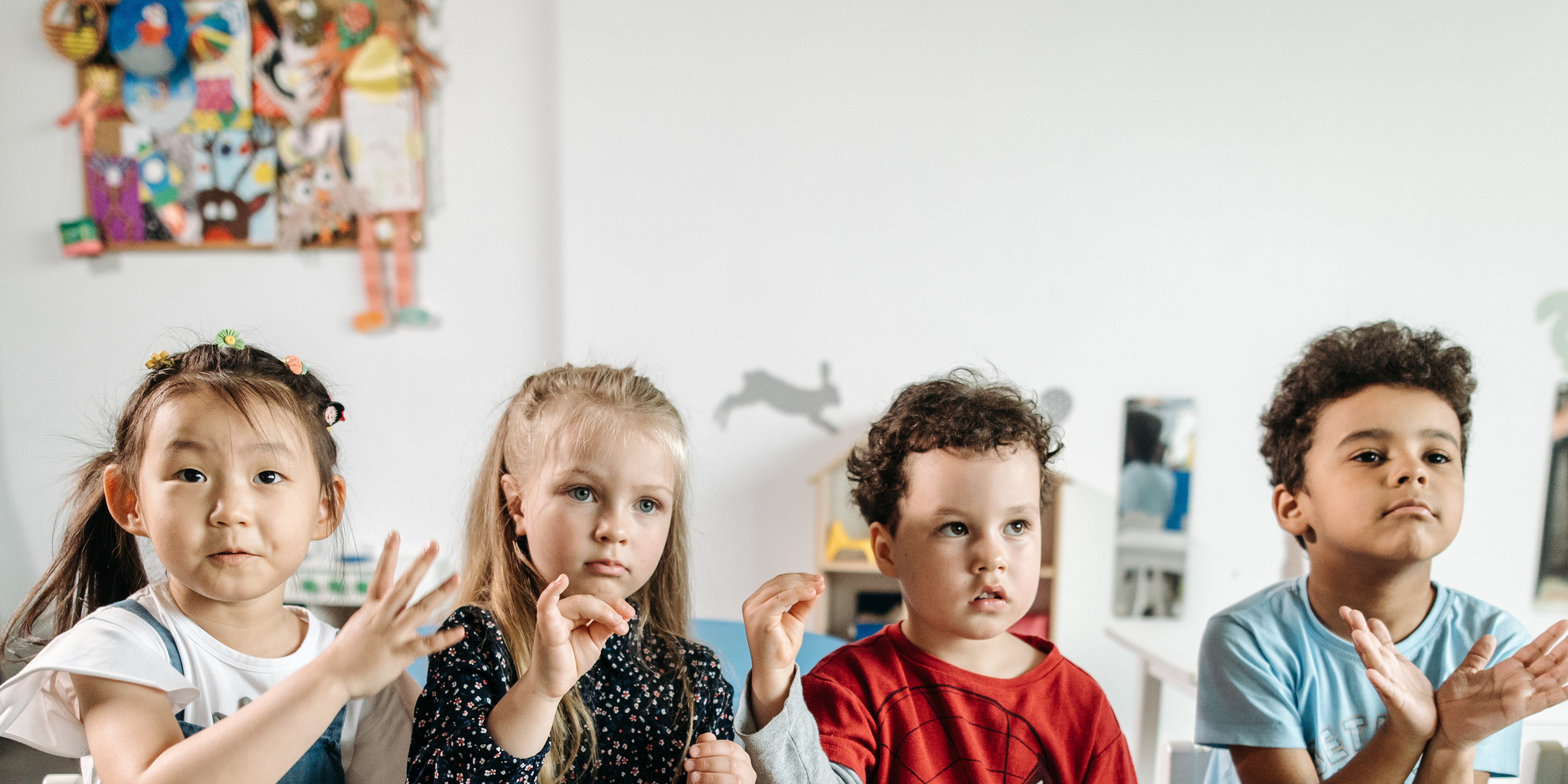 prek hero people sitting on chair in front of table while holding pens during daytime
