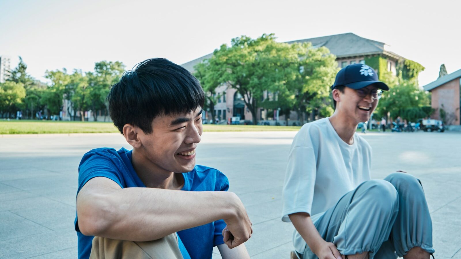 Photo by Y.H. Zhou man in white crew neck t-shirt sitting on blue chair